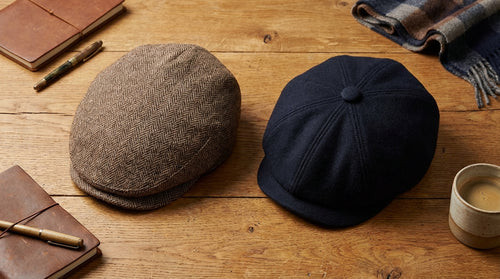 Sixpence og newsboy cap side om side på træbord